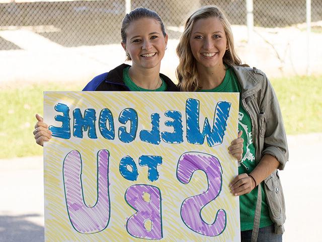 two girls holding welcome to S-B-U sign